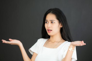 Siyah arka planda beyaz tişörtlü Asyalı genç kadın portresi