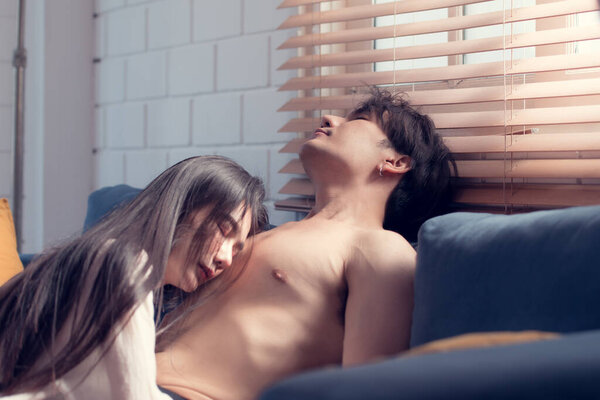 В гостиной дома сексуальная женщина в нижнем белье лежит на диване и влюбляется в свою супругу.