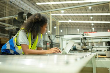 Makineyi kontrol etmek için dizüstü bilgisayar kullanan genç kadın mühendisler..
