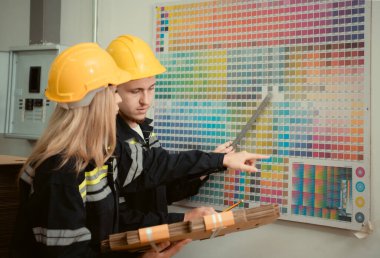 Üniformalı ve şapkalı depo işçileri kağıt fabrikasında çalışıyor.