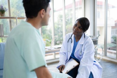 Hastanedeki hastanın diz eklem işlevini inceleyen doktor.