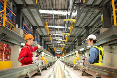Elektrikli tren tamir atölyesine park edildikten sonra, elektrikli tren mühendisi ve teknisyeni, denetim turuna uygun olarak demiryolu ve elektrik trenlerini teftiş ediyor.