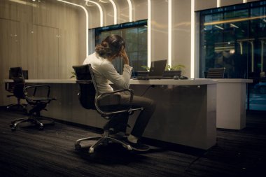 Masada oturan genç işadamının yan görünüşü ve bakışları iş hayal kırıklığı konsepti.