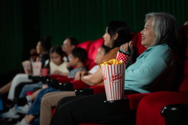 Sinemada film izleyen Asyalı anne ve kız. Aile zamanı kavramı.