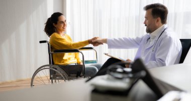 Tekerlekli sandalyedeki hasta doktorla el sıkışıyor. Sağlık ve Sağlık Hizmetleri.