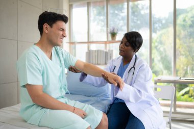 Hastanenin koğuşunda hastanın kolunu ve üst kolunu muayene eden doktor. Tıbbi ve sağlık hizmeti kavramı.