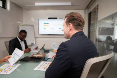 Masanın etrafında toplanan iki iş adamının arka görüşü