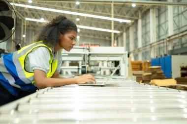 Makineyi kontrol etmek için dizüstü bilgisayar kullanan genç kadın mühendisler..