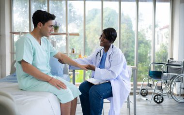 Hastanenin koğuşunda hastanın kolunu ve üst kolunu muayene eden doktor. Tıbbi ve sağlık hizmeti kavramı.