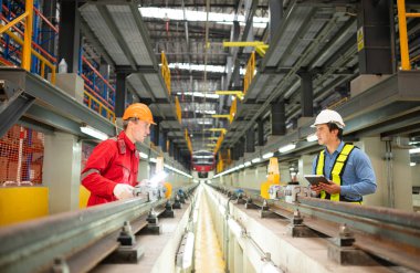 Elektrikli tren tamir atölyesine park edildikten sonra, elektrikli tren mühendisi ve teknisyeni, denetim turuna uygun olarak demiryolu ve elektrik trenlerini teftiş ediyor.
