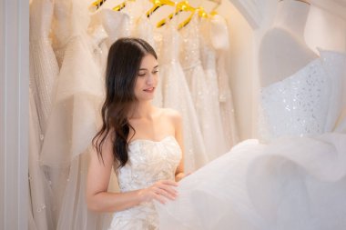 Gelinlik dükkanında gelinlik giyen Asyalı güzel bir kadının portresi.