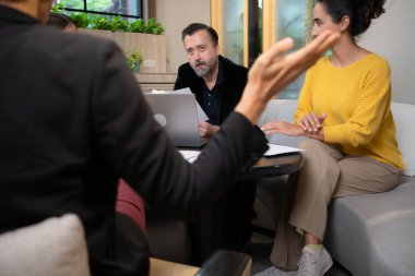 İş adamı ve iş kadını çalışma odasındaki bir projeyi tartışıyor.