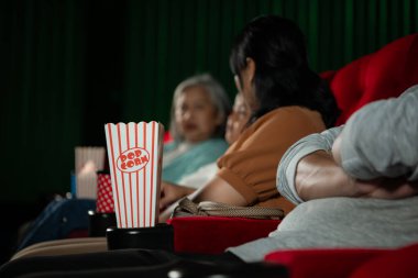 Sinema konsepti. Sinemada film izleyen insanlar su içip patlamış mısır yiyorlar.