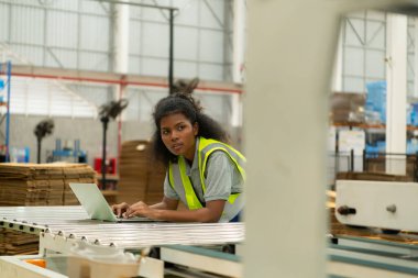 Makineyi kontrol etmek için dizüstü bilgisayar kullanan genç kadın mühendisler..