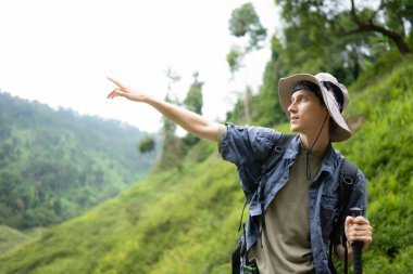 Sırt çantalı genç adam ormanda yürüyüş yapıyor. Etkin yaşam tarzı kavramı.
