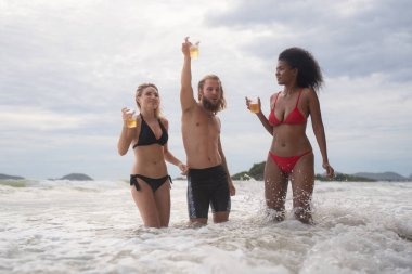 Bir grup arkadaş sahilde eğleniyor. Genç kadınlar sahilde eğleniyor..