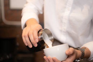 Barista kahve dükkanındaki fincana kahve dolduruyor, yakın plan.