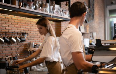 Barista kafede çalışıyor. Kahve dükkanında tezgahın arkasında duran genç bir baristanın portresi..