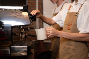 Barista kahve dükkanındaki fincana kahve dolduruyor, yakın plan.