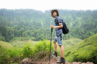 Sırt çantalı genç adam ormanda yürüyüş yapıyor. Etkin yaşam tarzı kavramı.
