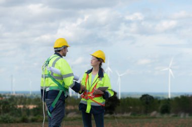 Mühendis ve teknisyen içeri girmeden önce rüzgar türbininin doğal enerji kavramını kontrol etmeyi tartışıyorlar..