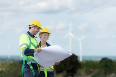 Mühendis ve teknisyen içeri girmeden önce rüzgar türbininin doğal enerji kavramını kontrol etmeyi tartışıyorlar..