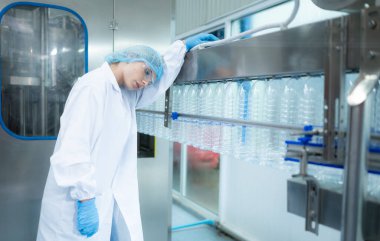 Laboratuvarda çalışan yorgun kadın bilim adamı içme suyu kalitesini kontrol ediyor.