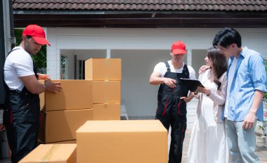 Paket kutularını kamyonun önündeki müşteriye teslim eden teslimatçı ve belgedeki kutu için müşteri tabelaları.