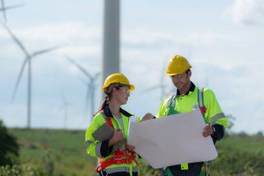Mühendis ve teknisyen içeri girmeden önce rüzgar türbininin doğal enerji kavramını kontrol etmeyi tartışıyorlar..