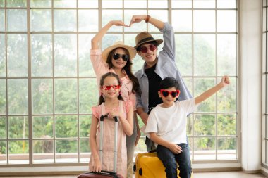 Father, mother, son and daughter packing for a weekend trip and  ready to go. clipart