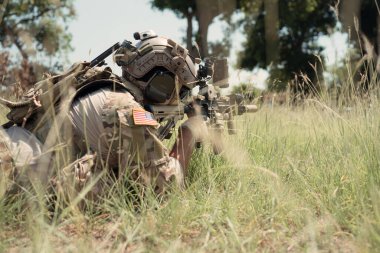 Kamuflajlı özel kuvvetler askerleri modern teknolojiyle dolu ve savaşa hazır bir çift silahla.