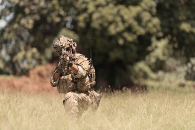 Kamuflajlı özel kuvvetler askerleri modern teknolojiyle dolu ve savaşa hazır bir çift silahla.