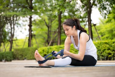 Sağlıklı yoga aktiviteleriyle parktaki tahta köprüde genç bir kadın.