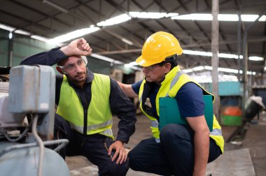 Teknisyen takım lideri sıkı çalışmaktan yorulan takımı teşvik ediyor. Şirketin eski makine deposundaki normal işleyişine dönmek için eski makineleri tamir etmek.