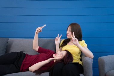 Evde tatil aktiviteleri olan LGBT çifti, sohbet etmek, konuşmak, film izlemek, neşeli bir ruh hali içinde müzik dinlemek gibi..