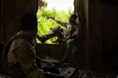 Kamuflajlı Özel Kuvvetler askerleri, yeni bir devriye operasyonu başlatmadan önce terk edilmiş bir binaya sığının..
