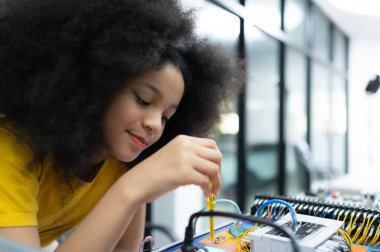 El robotu teknolojisini kullanan gençler, STEM kurslarından biri olan el robotu teknolojisinin elektronik devre kartını öğrenirken eğleniyorlar..