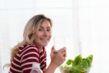 Temiz içme suyu olan genç bir dişi, ki bu onun sağlığı için çok önemlidir, hastalıktan uzak tutar ve cildinin parlamasına yardımcı olur..