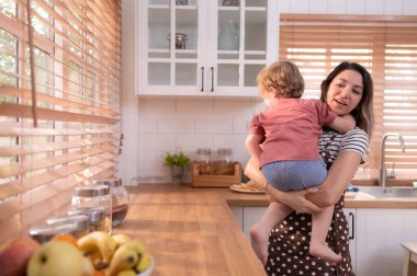 Anne evin mutfağında küçük bir çocukla. Oyun oynayın ve birlikte yemek pişirin..