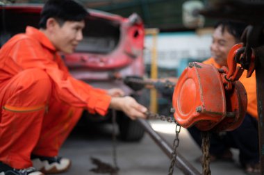 Otomobil gövdesini eski şekline döndürmek için, araba tamircisi ağır bir çarpışma sonucu oluşan gövdeyi deforme olana kadar çekmek için bir makine kullanır..
