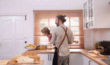 Baba evin mutfağında küçük bir çocukla. Oyun oynayın ve birlikte yemek pişirin..
