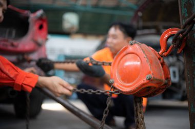 Otomobil gövdesini eski şekline döndürmek için, araba tamircisi ağır bir çarpışma sonucu oluşan gövdeyi deforme olana kadar çekmek için bir makine kullanır..