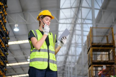 Otomobil parçaları deposunda çalışan kadın işçi otomobil montaj fabrikasına gönderilmeye hazır otomobil parçalarını inceliyor..