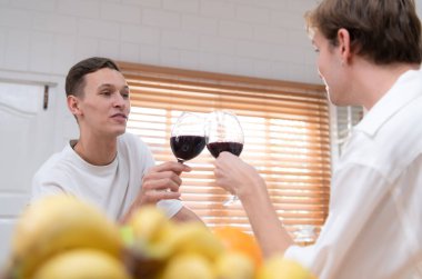 LGBT genç çifti, aşk gününü evin mutfağında kaliteli şarapla kutluyor.