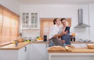 Genç çift mutfağa gidip çevrimiçi kurabiye yapmayı öğreniyor. Yap, mutlu ol ve eğlen..