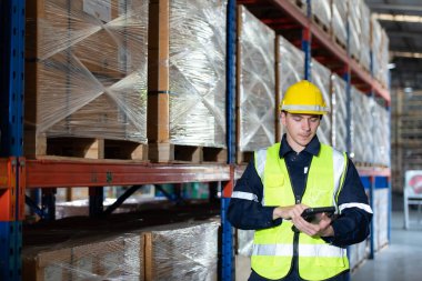 Otomobil parçaları deposunda çalışan bir işçi başkanı otomobil montaj fabrikasına gönderilmeye hazır otomobil parçalarını inceliyor..