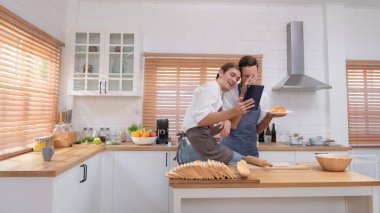 Genç çift mutfağa gidip çevrimiçi kurabiye yapmayı öğreniyor. Yap, mutlu ol ve eğlen..