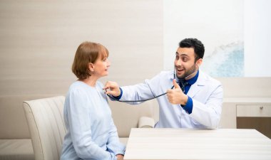 Kadın yaşlanıyor, yıllık sağlık ve sağlık kontrollerine katılıyor ve hastanede doktorla konuşuyor.