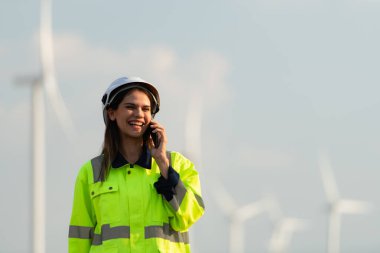 Doğal Enerji Rüzgâr Türbini bölgesindeki kadın mühendis büyük rüzgar türbinlerinin bakımından sorumlu. Telefonu kullanarak ailenle iletişim kur ki seni özleyebilsinler.