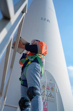 Doğal enerji rüzgar türbini alanındaki mühendis çalışmadaki doğruluğu kontrol etmek için bir bilgisayar kullanmalı